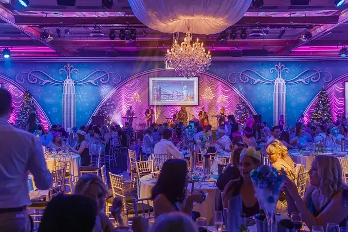 Elegant ballroom setup for one of the Gold Coast Christmas events, featuring festive lighting, chandeliers, and guests dining during a live holiday performance.